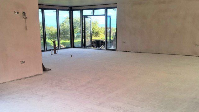 Empty unfurnished room with large glass doors overlooking greenery