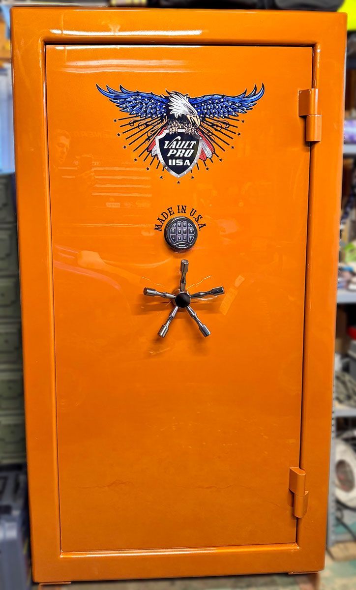 Orange metal safe with eagle emblem and circular lock on the door.