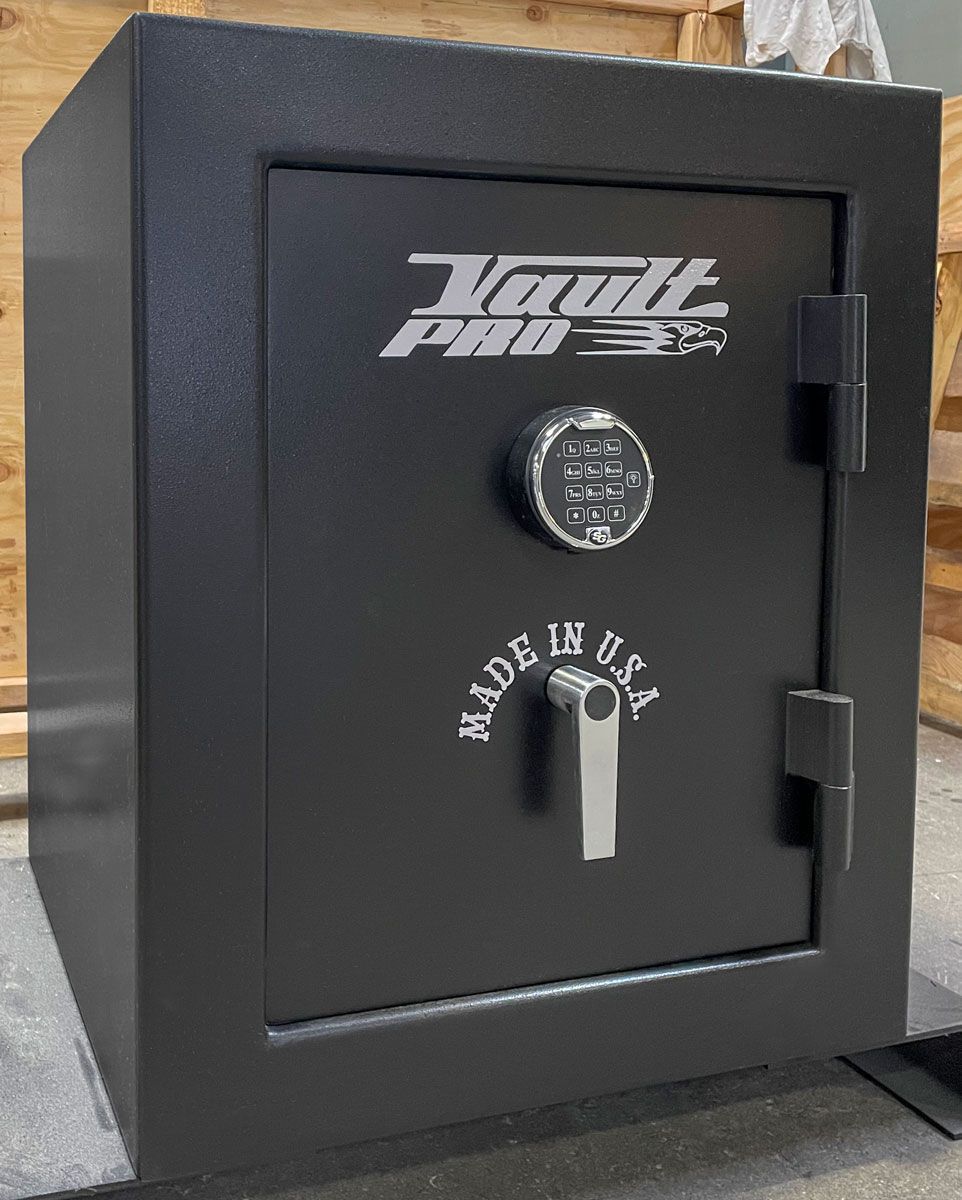 Black fireproof safe door with keypad lock and white logo on a gray floor