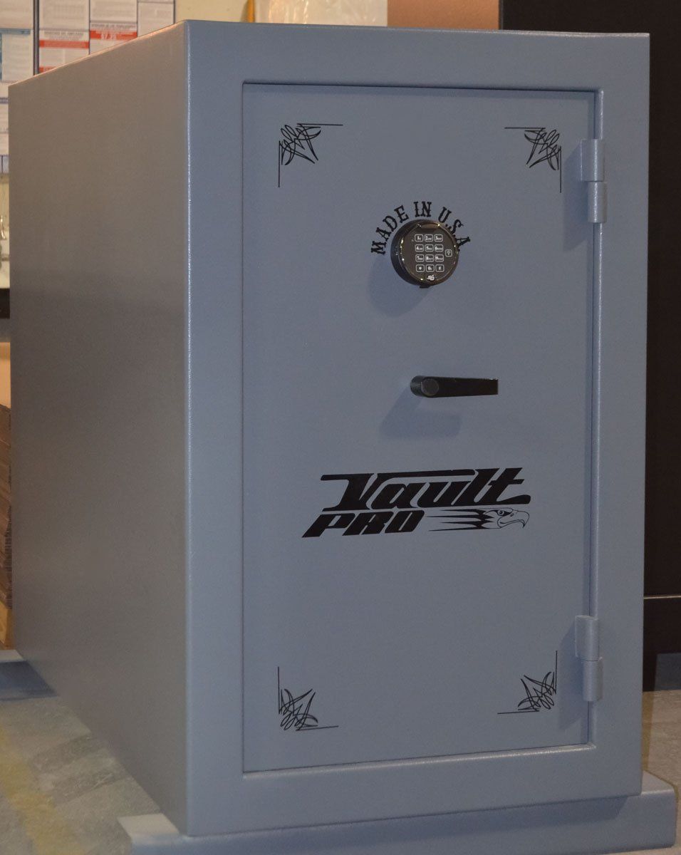 Gray metal safe with a dial lock and handle, viewed from the front on a carpeted floor.