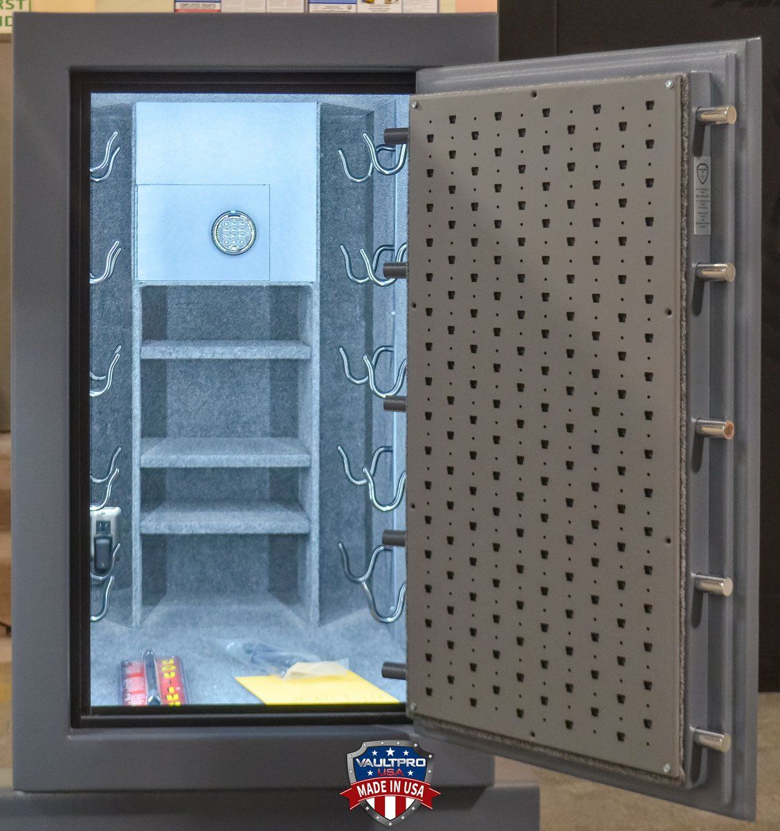 Open safe with gray interior shelves and pegboard door, showing small items inside.