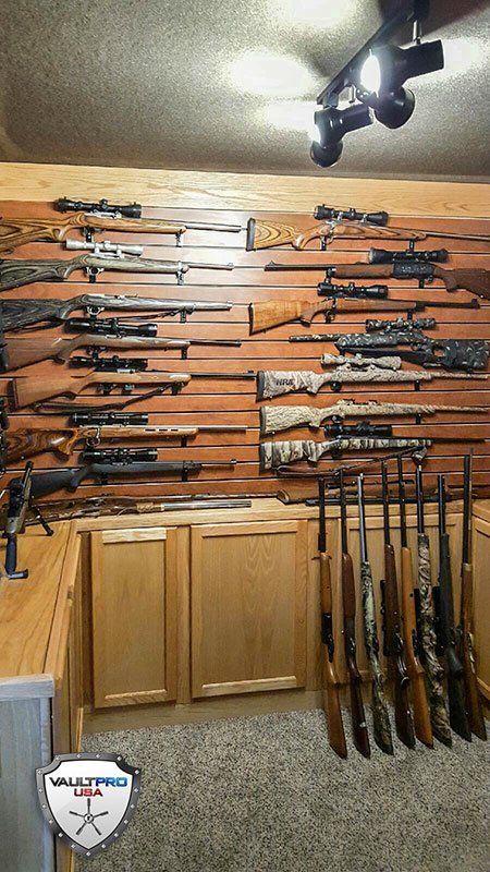 walk in vault with oak cabinets and rifle and pistol racks