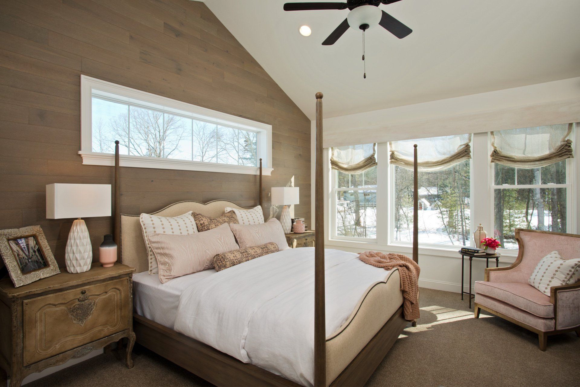 Primary bedroom with eye-catching accent wall and cathedral ceiling