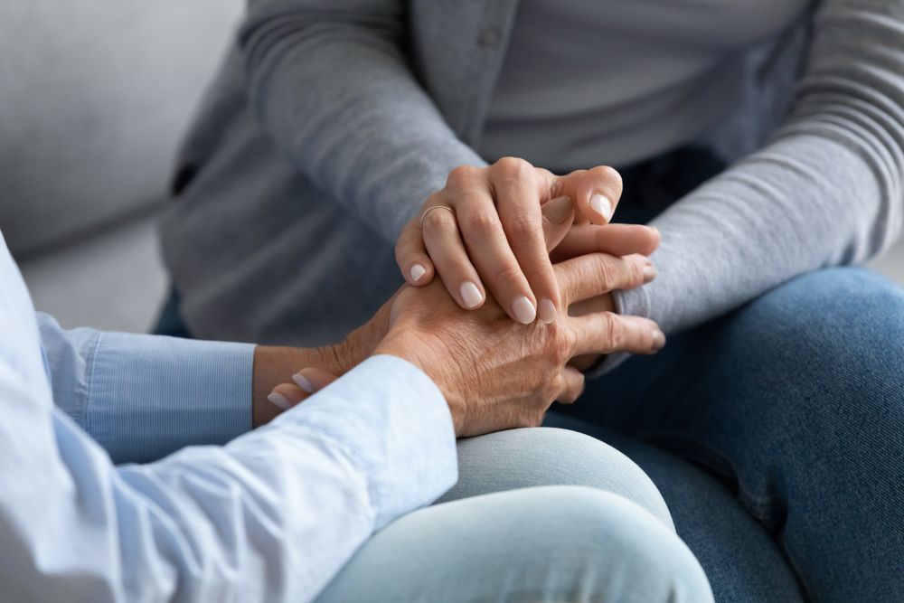 Two People Holding Hands, Offering Support, One Wearing a Blue Shirt — Premium Aged & Community Services In Tamworth, NSW
