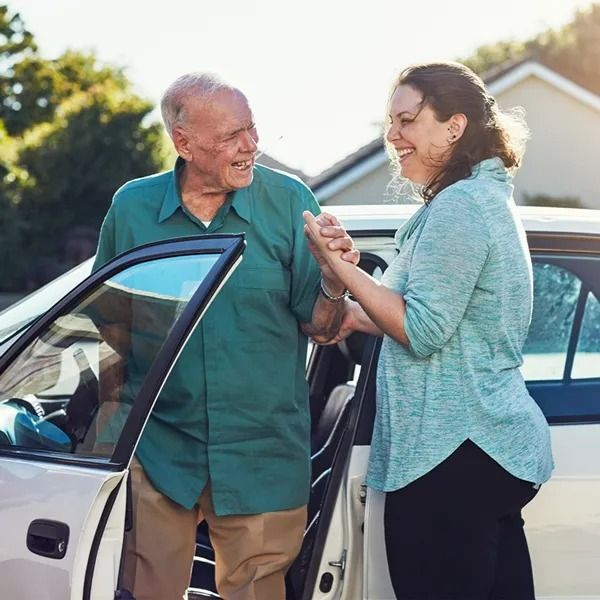 A Woman Is Helping an Older Man Get out Of a Car — Aged Care in Tamworth, NSW