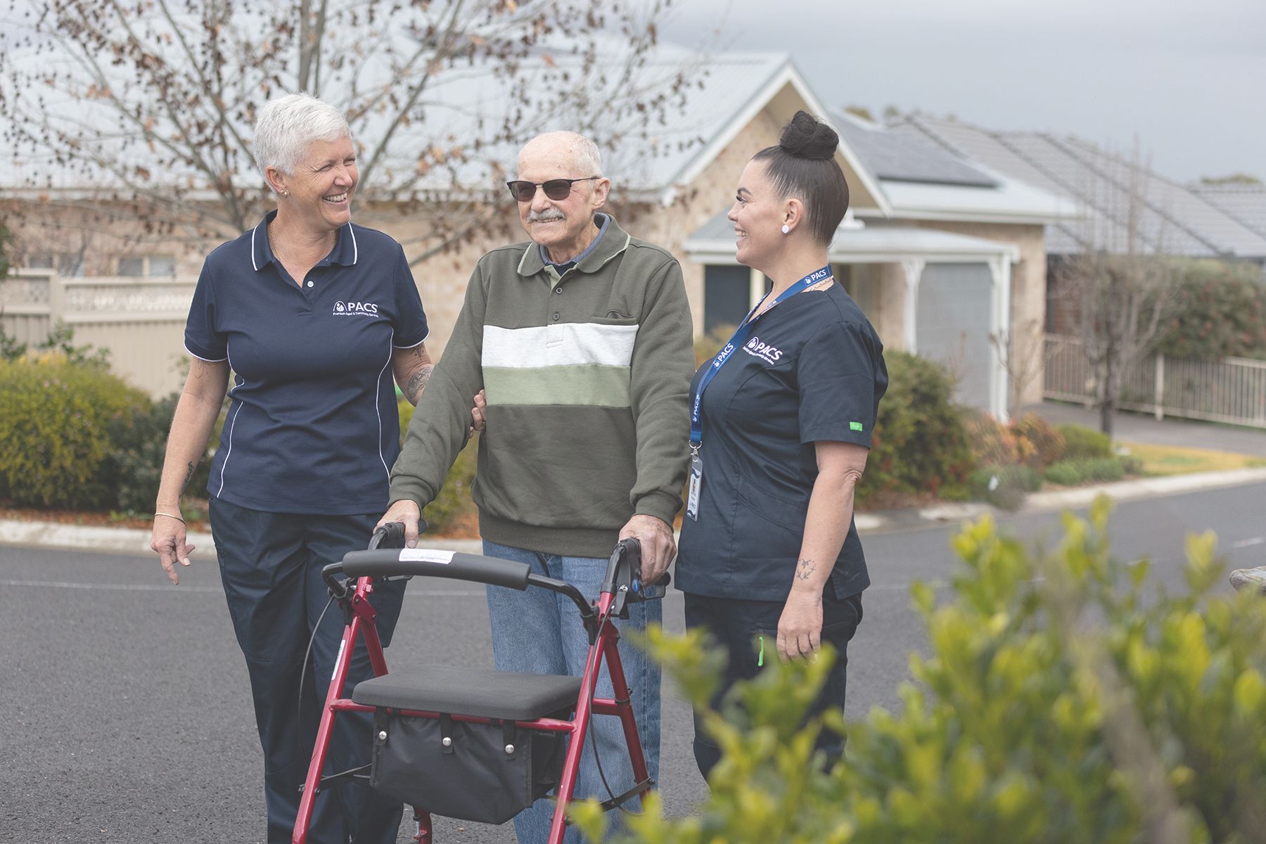 Two People Assisting a Man Using a Walker Outdoors — Premium Aged & Community Services In Tamworth, NSW