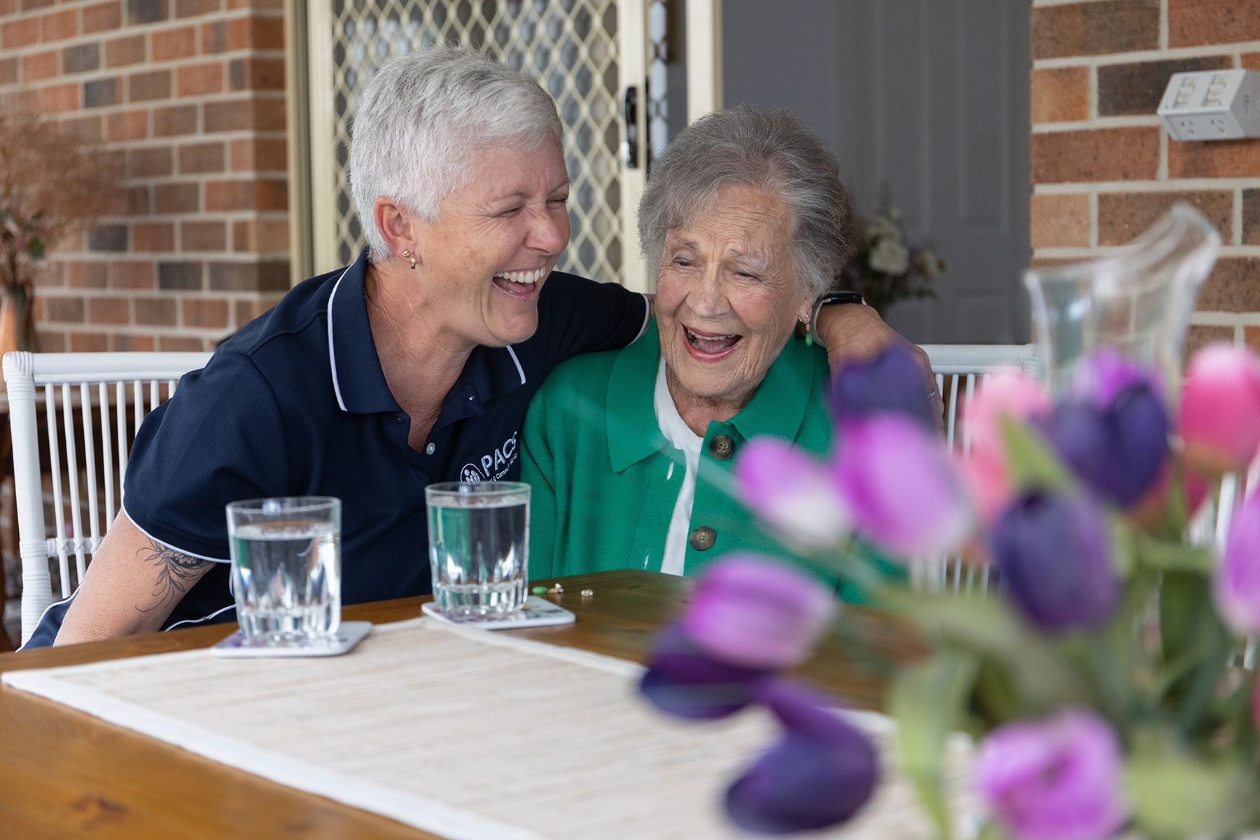 Woman Hugs and Laughs With Another Woman — Premium Aged & Community Services In Armidale, NSW