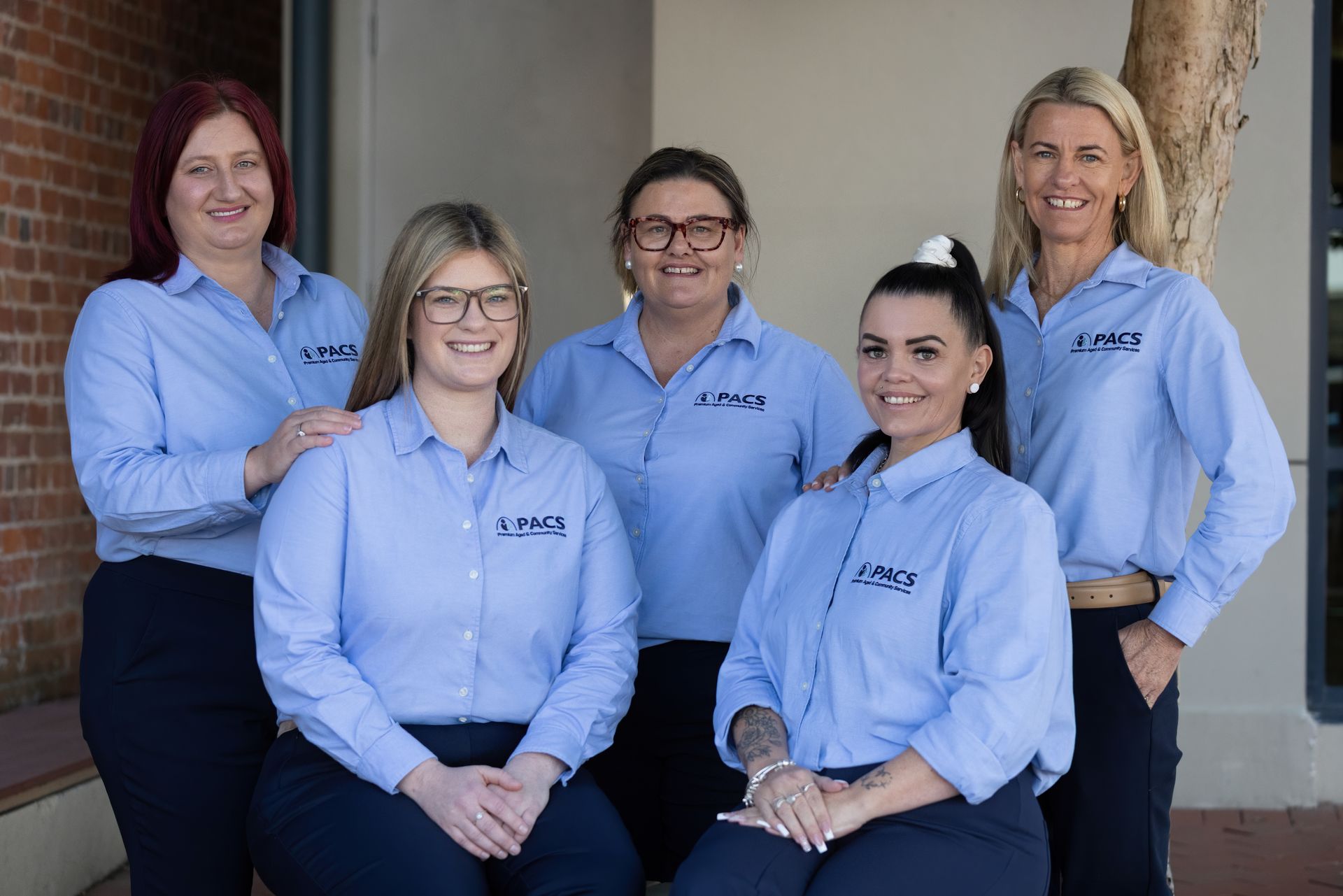 Five Women in Matching Blue Shirts Pose Together Outdoors — Premium Aged & Community Services In Tamworth, NSW