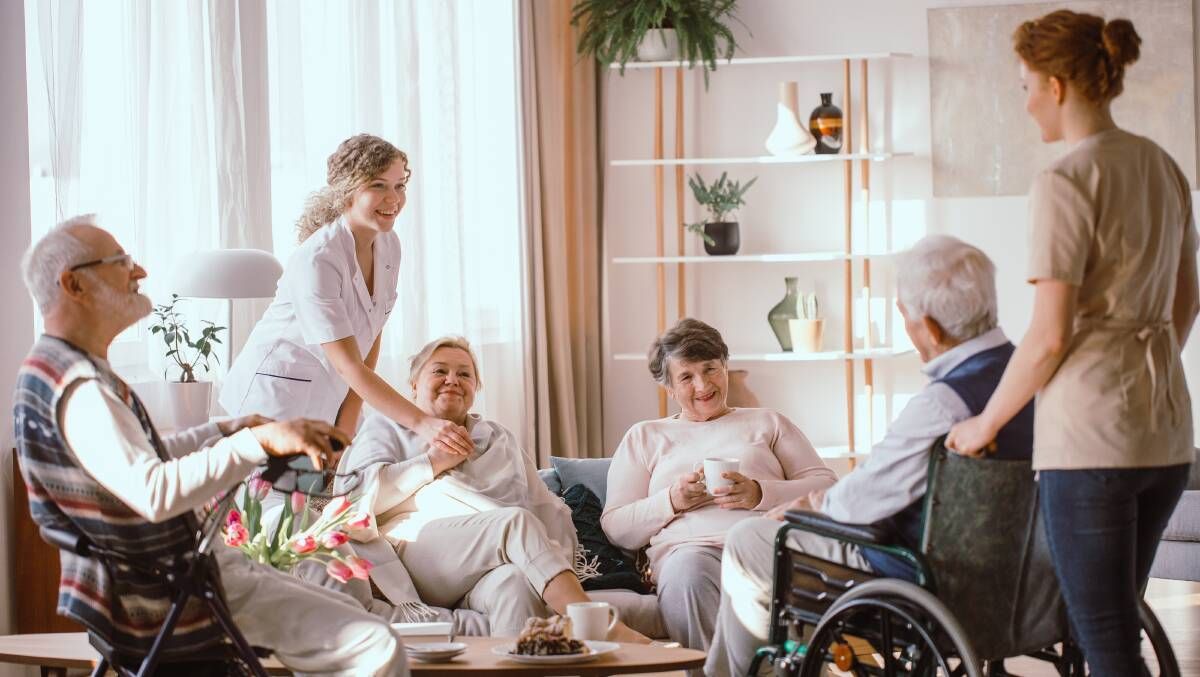 A group of elderly people are sitting on a couch in a living room — Aged Care in Tamworth, NSW