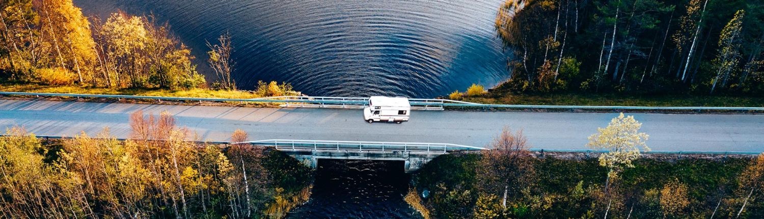 Bird's eye view of an RV driving on a scenic bridge Bird's eye view of an RV driving on a scenic bridge