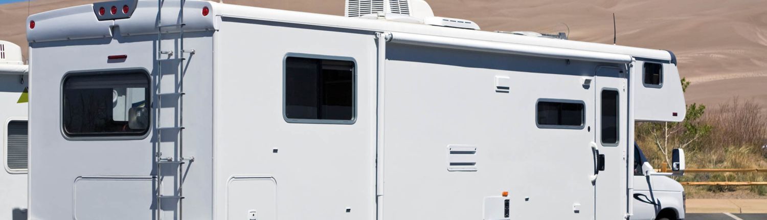 new RV vs used RV financing May Blog 2 A white rv is parked on the side of the road.