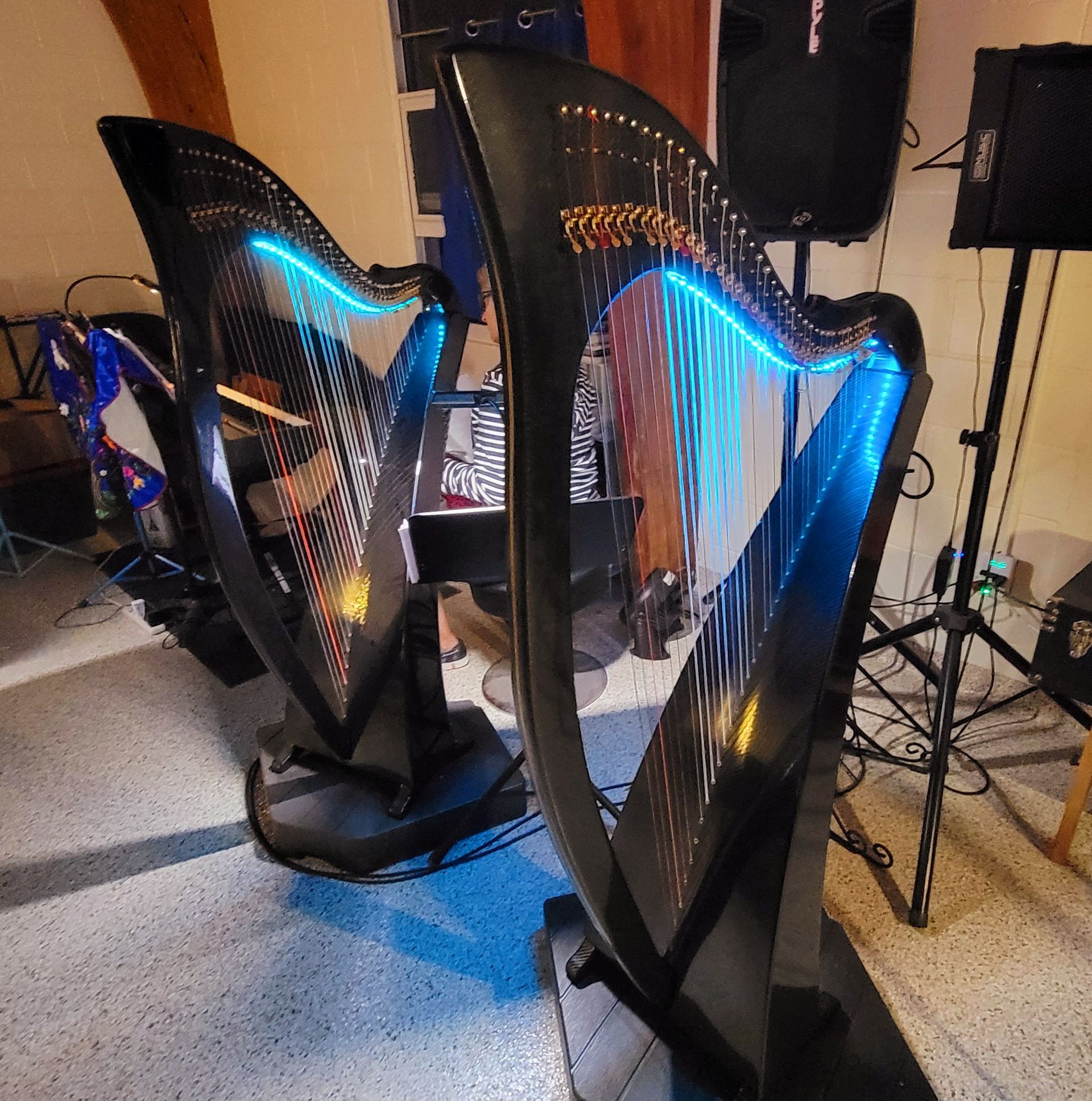 Two black harps with blue LED lights on a stage.