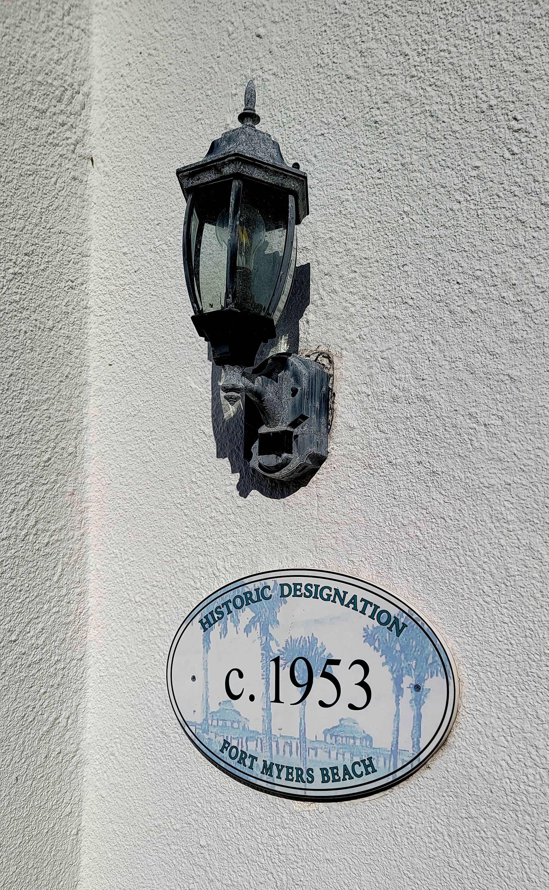 Weathered wall-mounted lamp and sign. Sign: 
