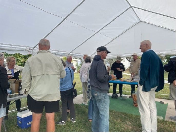 A group of people standing under a white tent