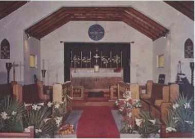 The inside of a church with a red carpet leading to the altar