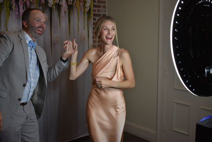 A bride and groom are posing for a picture in a photo booth.