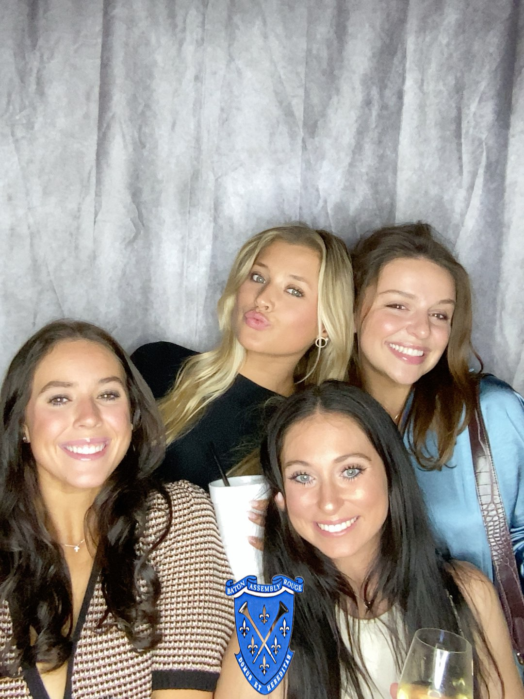 A group of women are posing for a picture in a photo booth.