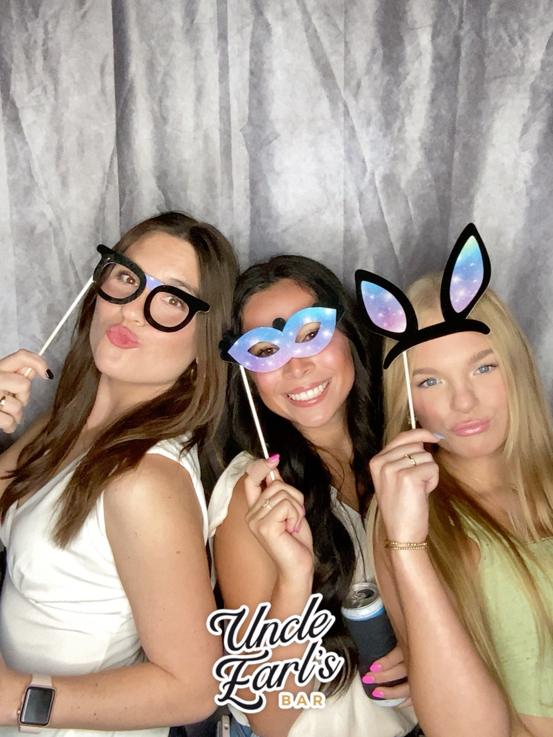 Three women are posing for a picture in a photo booth in baton rouge