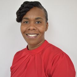 A woman in a red shirt is smiling for the camera.