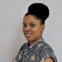 A woman with her hair in a bun is smiling for the camera.