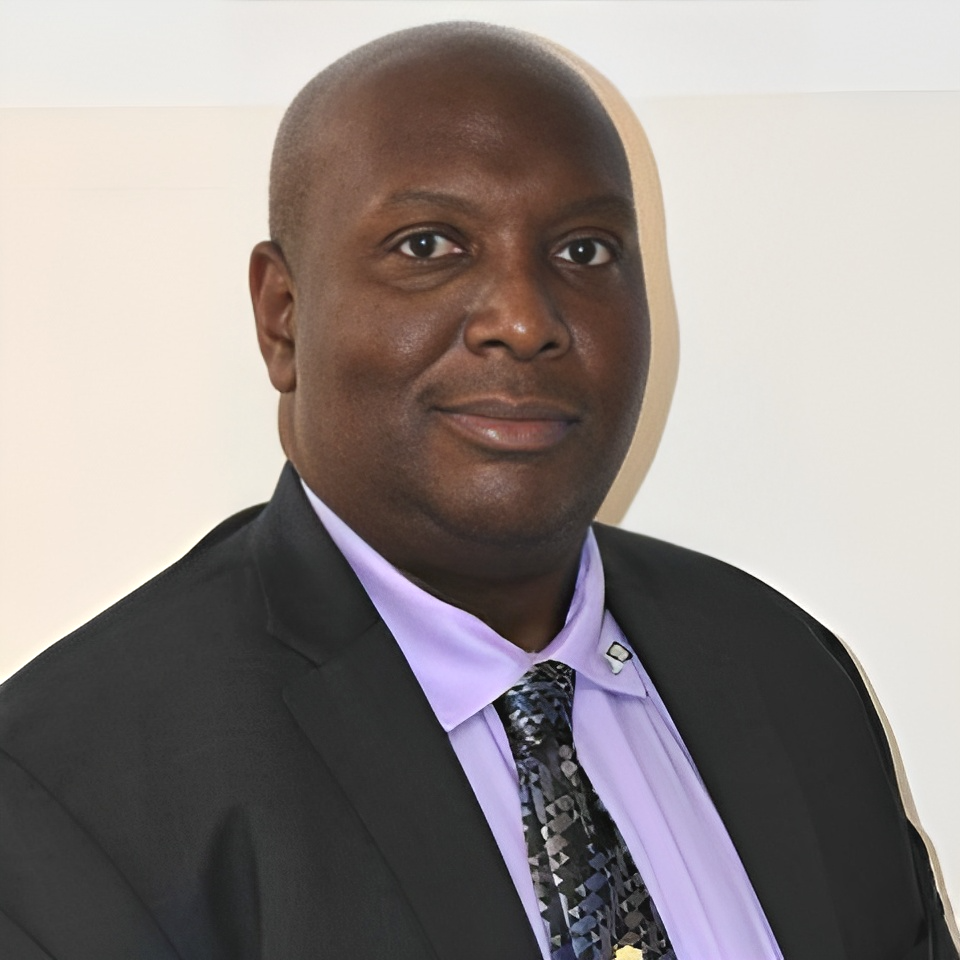 A man in a suit and tie is smiling for the camera