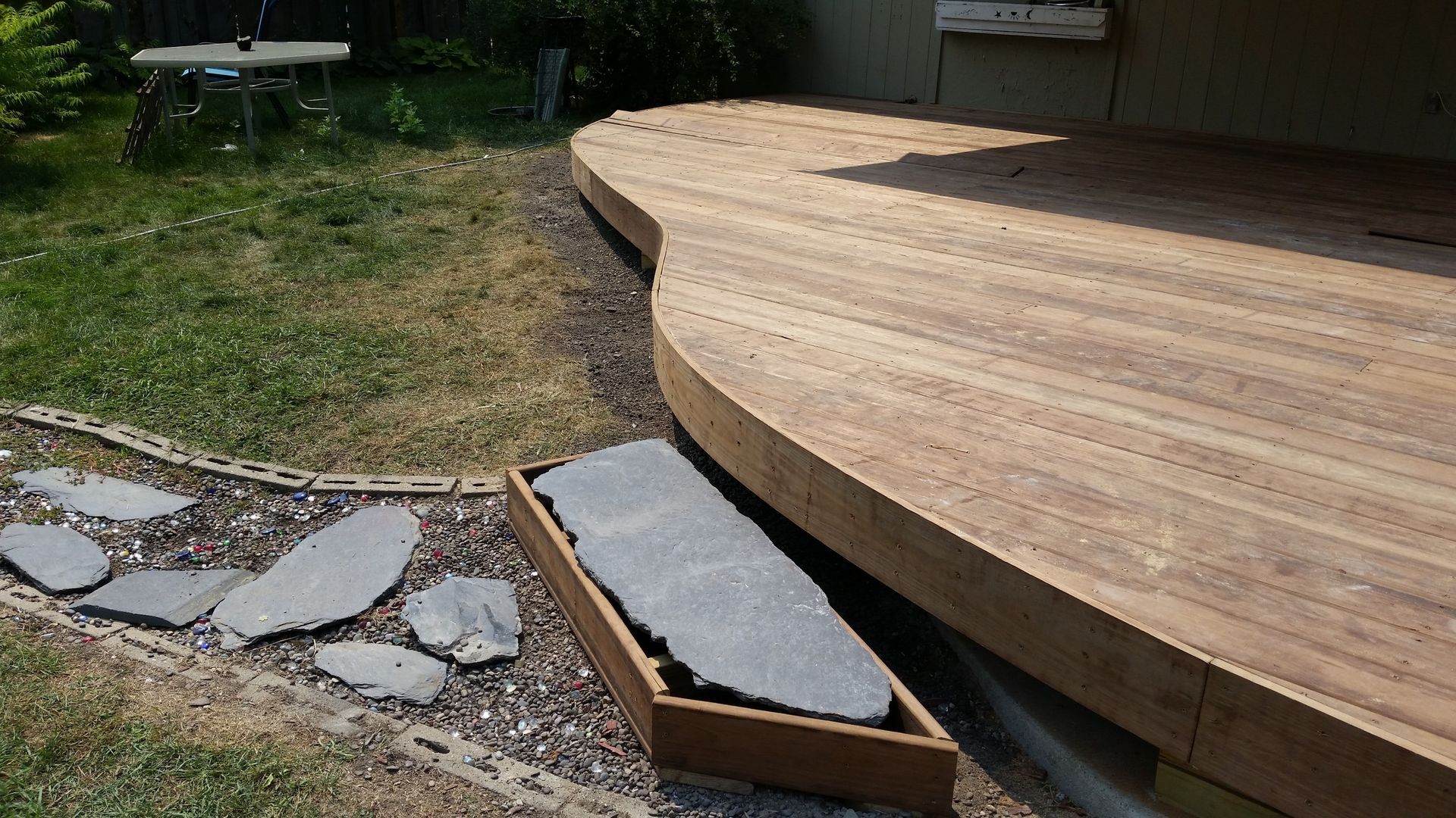 A wooden deck is being built in a backyard