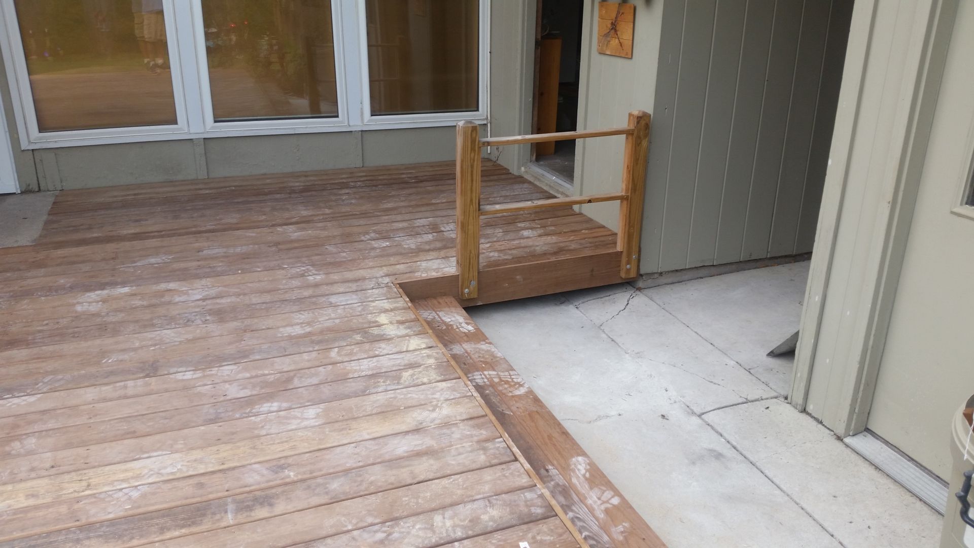 A wooden deck with a ramp leading to a door.