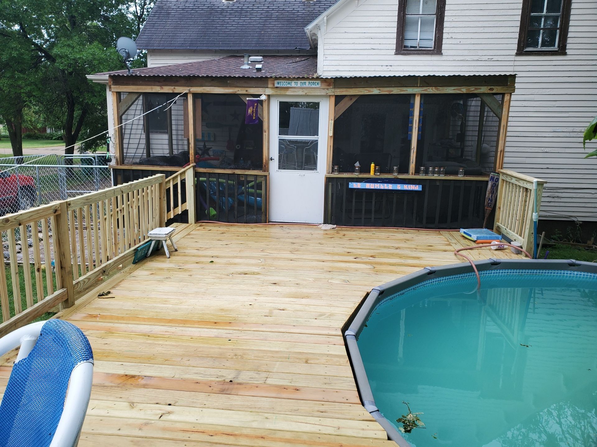A screened in porch with a swimming pool in front of it