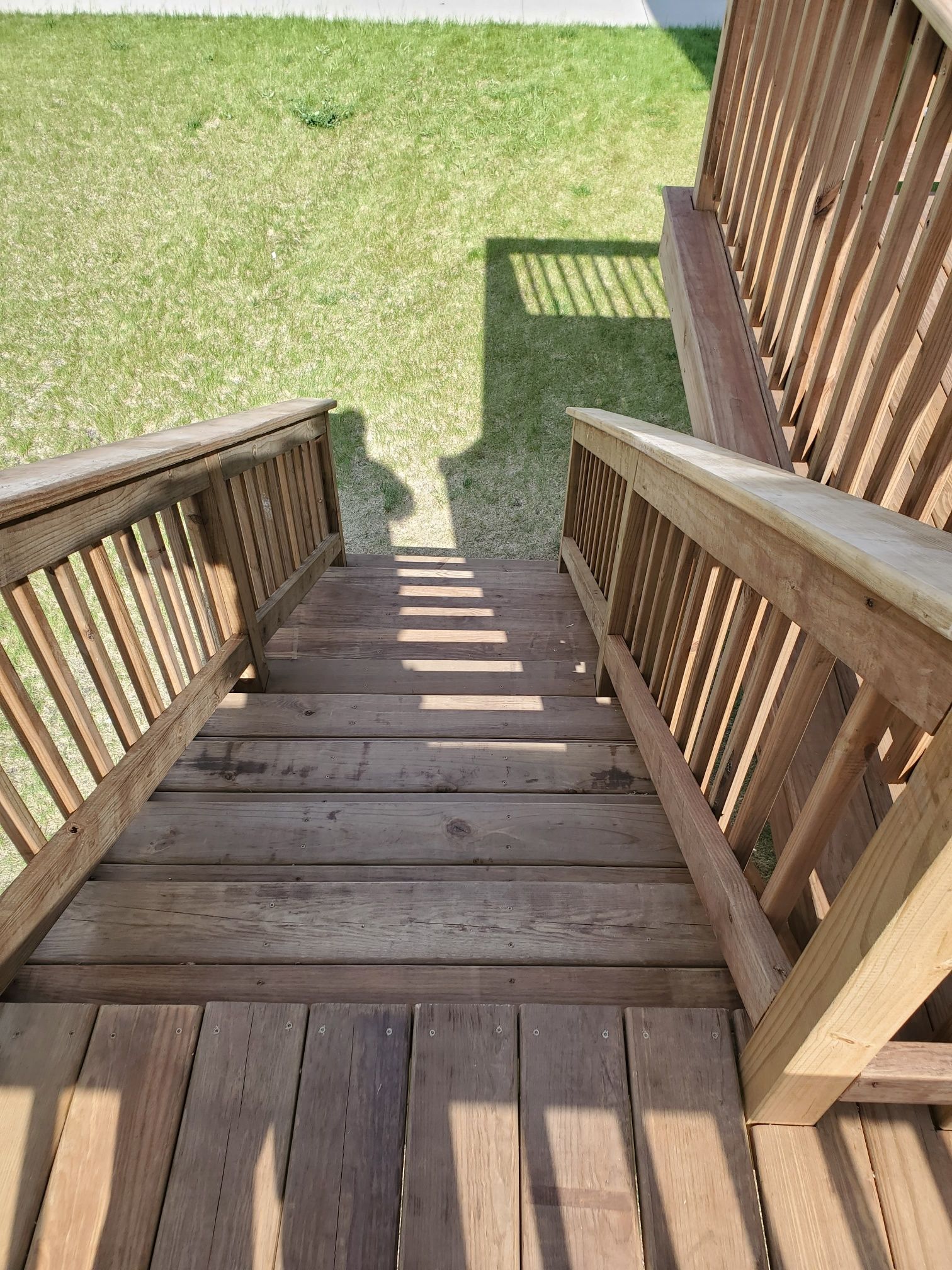 A wooden deck with stairs leading up to it and a bench.