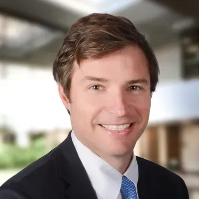 A man in a suit and tie is smiling for the camera