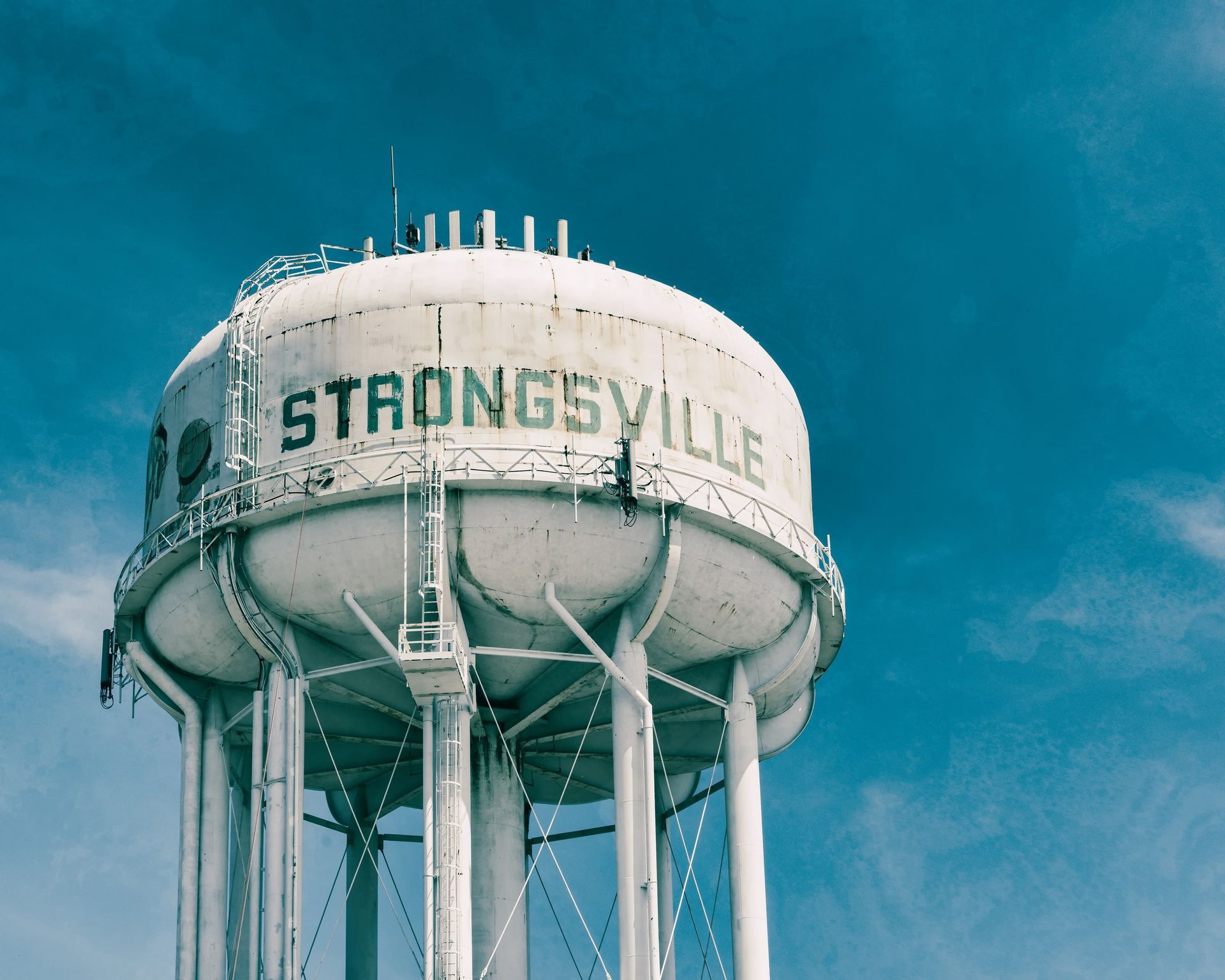 White STRONGSVILLE water tower against a blue sky