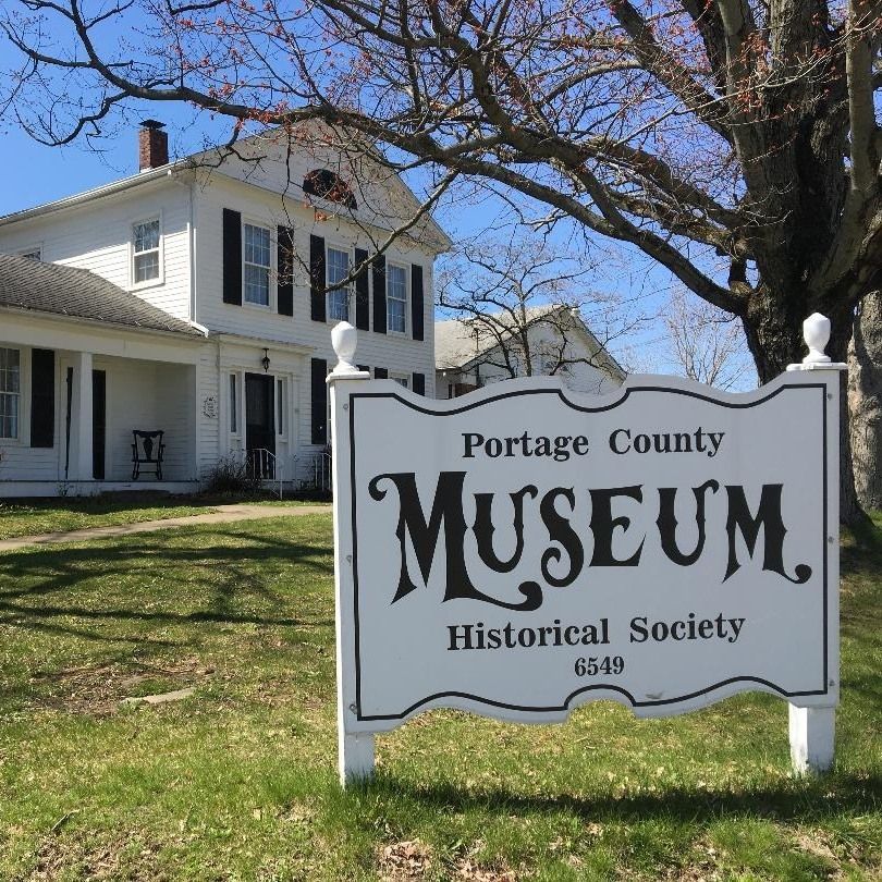 Portage County Museum sign in front of a white historic house on a sunny day