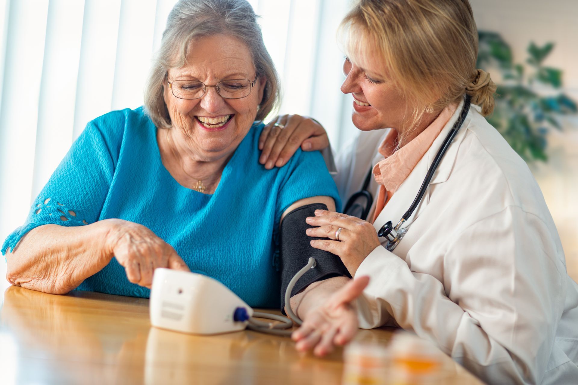 Senior adult woman learning from a nurse to use a blood pressure machine. Senior adult woman learning from a nurse to use a blood pressure machine.