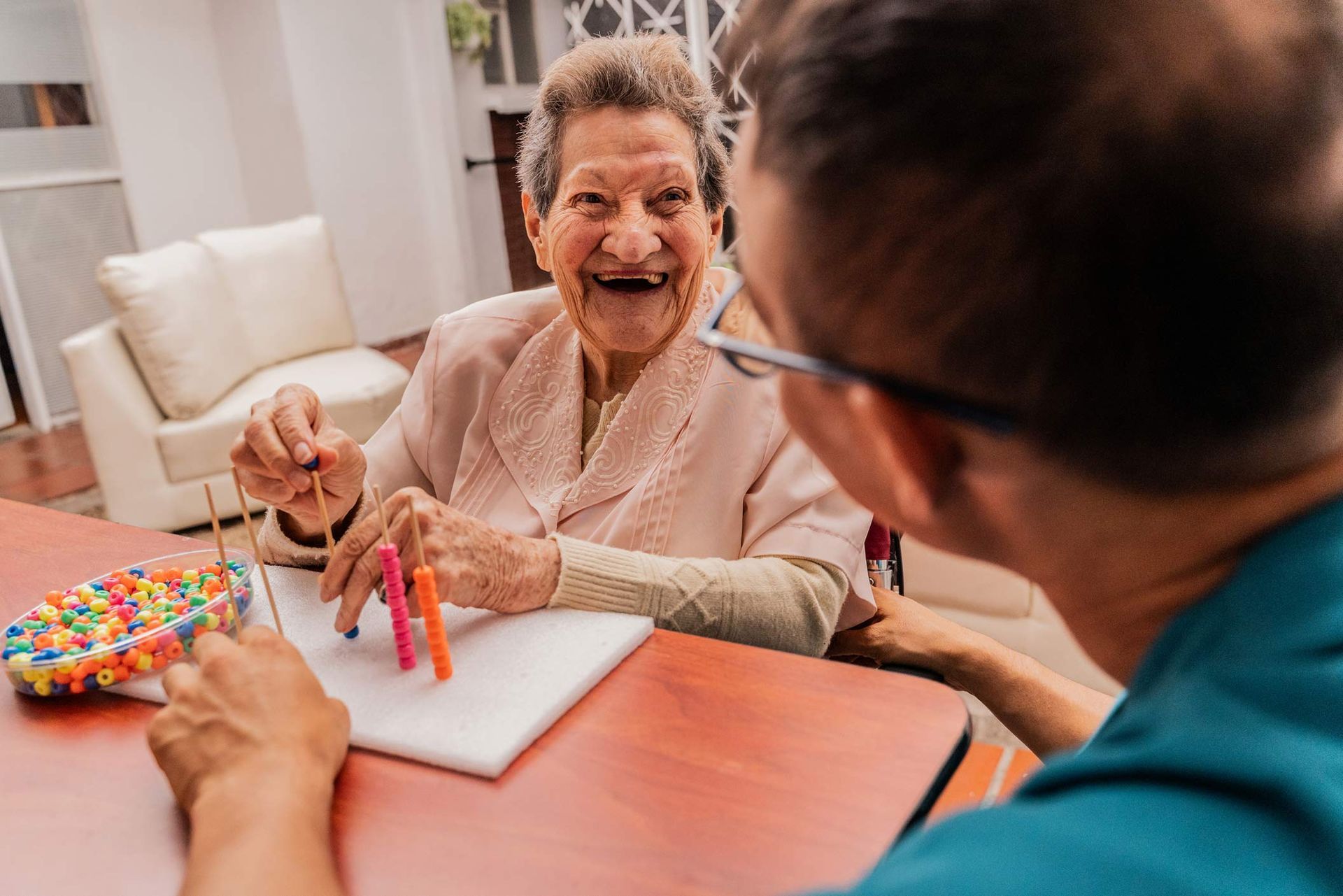 Senior woman and caregiver playing with abaco toy at home Senior woman and caregiver playing with abaco toy at home