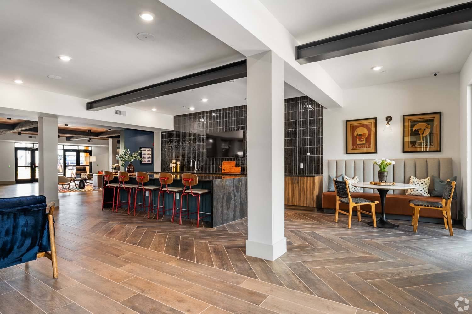 A large room with a wooden floor , tables and chairs.
