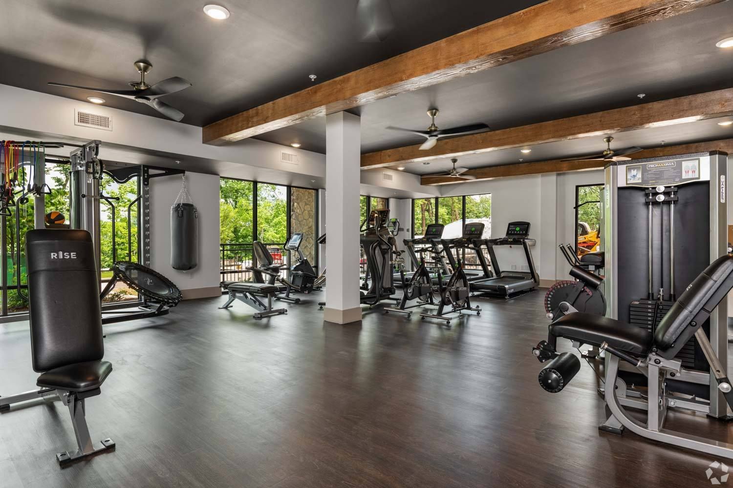 A large gym filled with lots of exercise equipment.