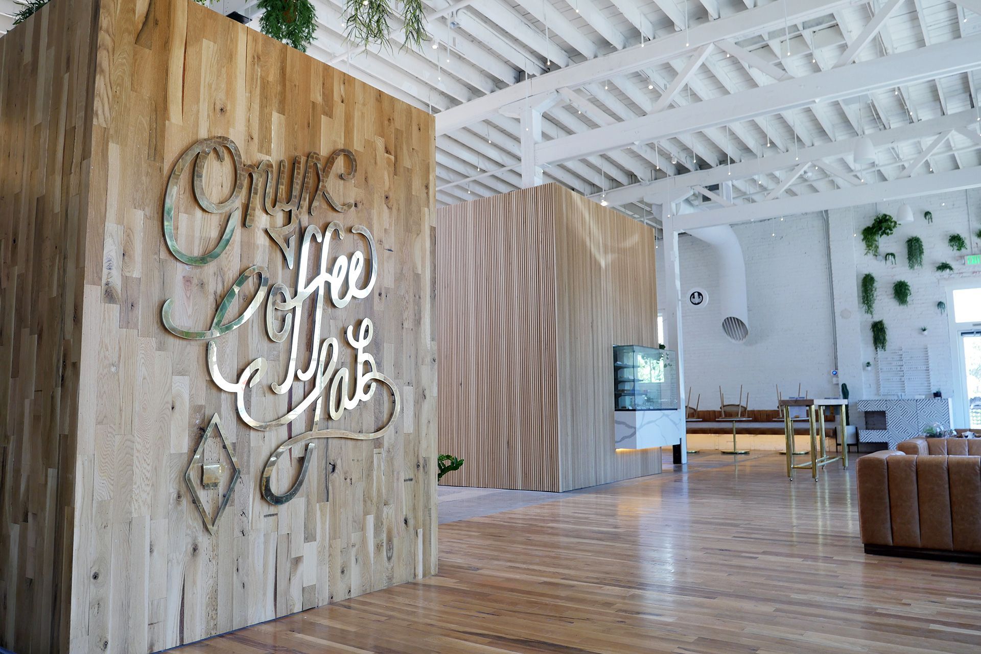 A coffee shop interior with wooden walls and large silver lettering.