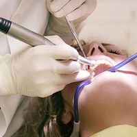 Dentist using tools to treat a patient’s teeth during a dental exam