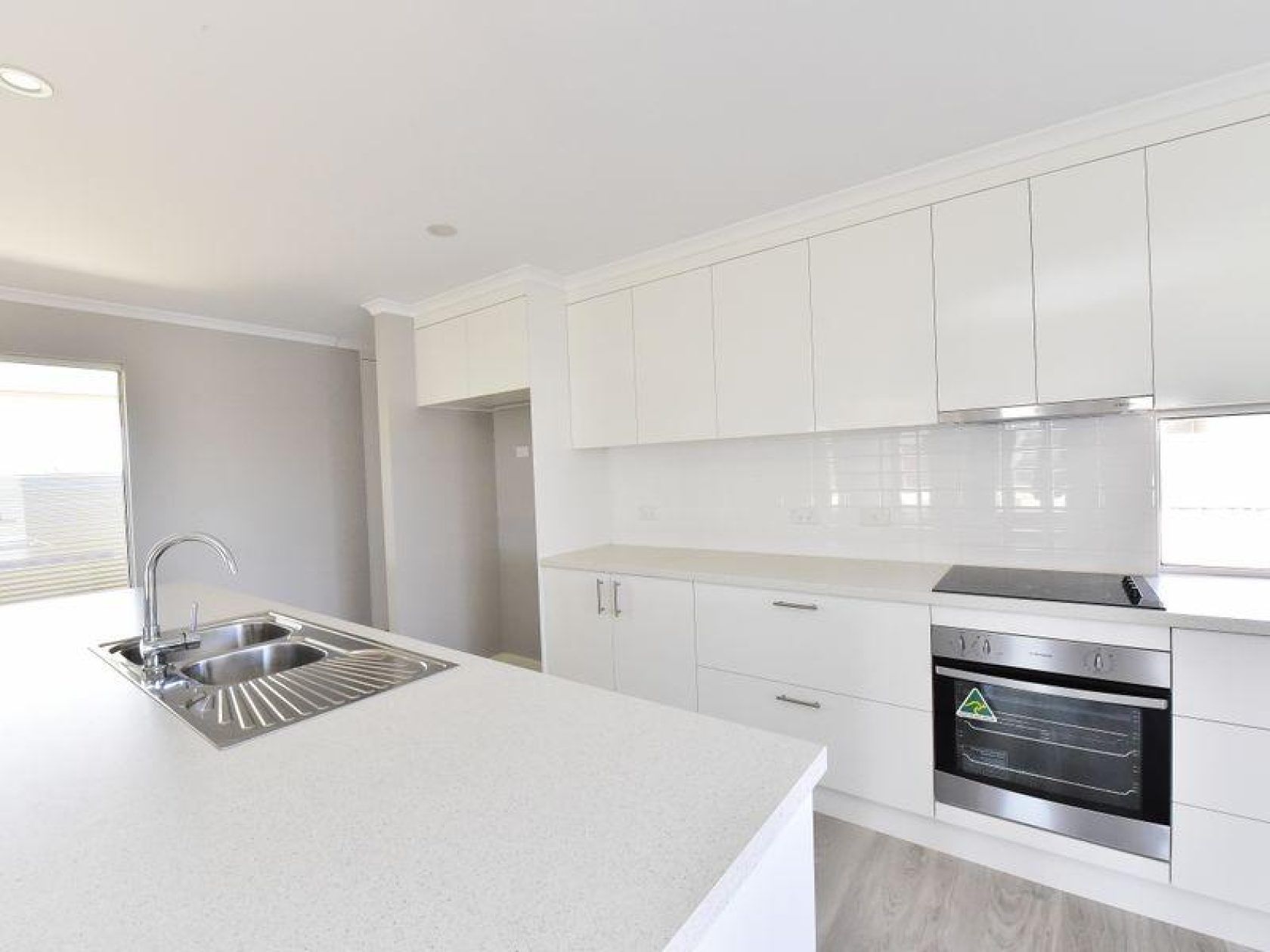 White kitchen with island, cabinets, and oven; a modern, bright interior.