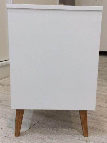 White cabinet with wooden legs.