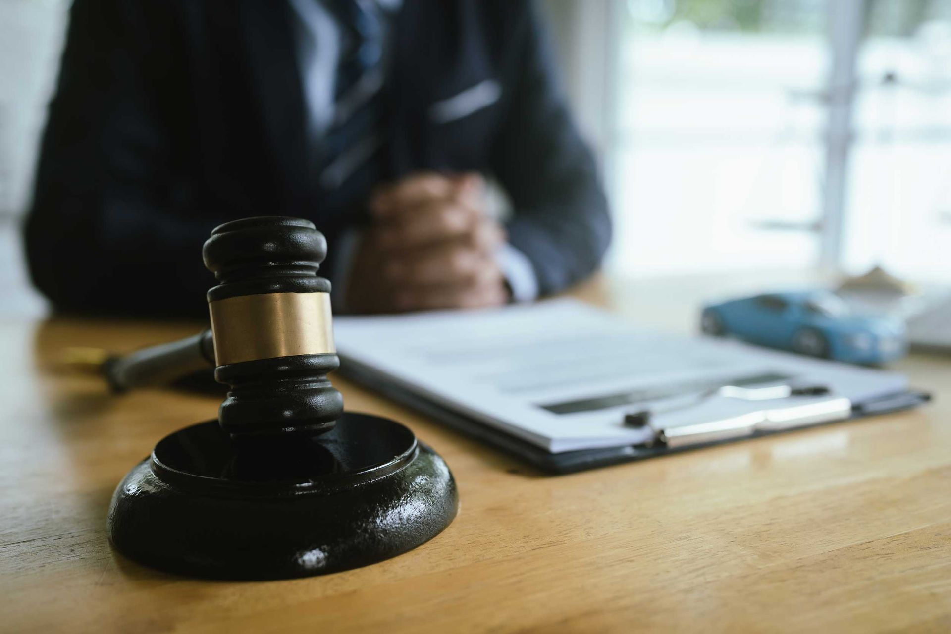A gavel with a lawyer in the background. A gavel with a lawyer in the background.