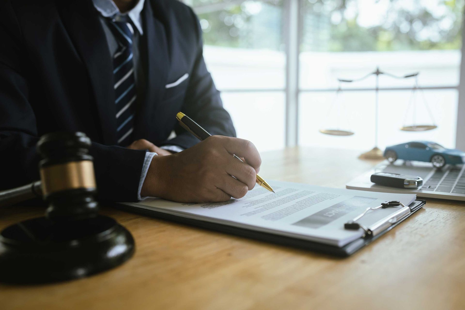A lawyer in a suit signs legal documents with pen. A lawyer in a suit signs legal documents with pen.