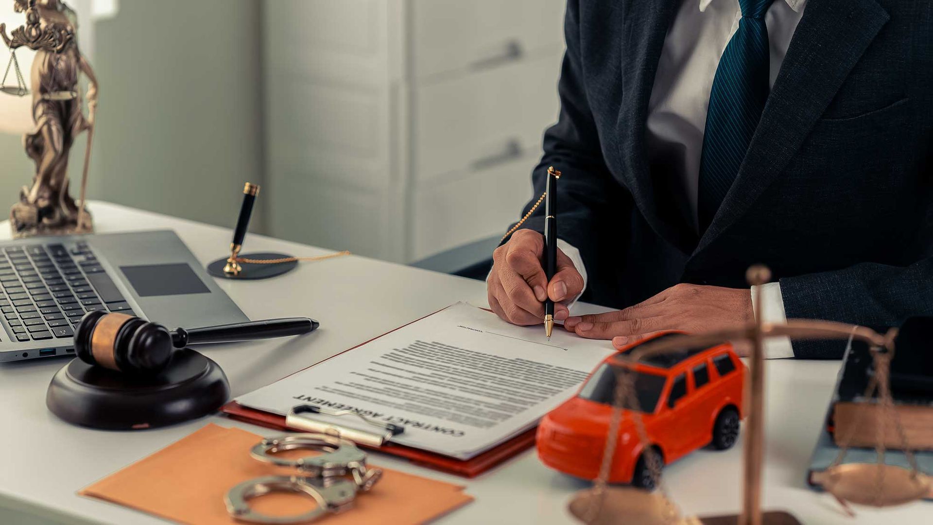 Experienced truck accident lawyer reviewing legal documents at desk with gavel and scales. Experienced truck accident lawyer reviewing legal documents at desk with gavel and scales.