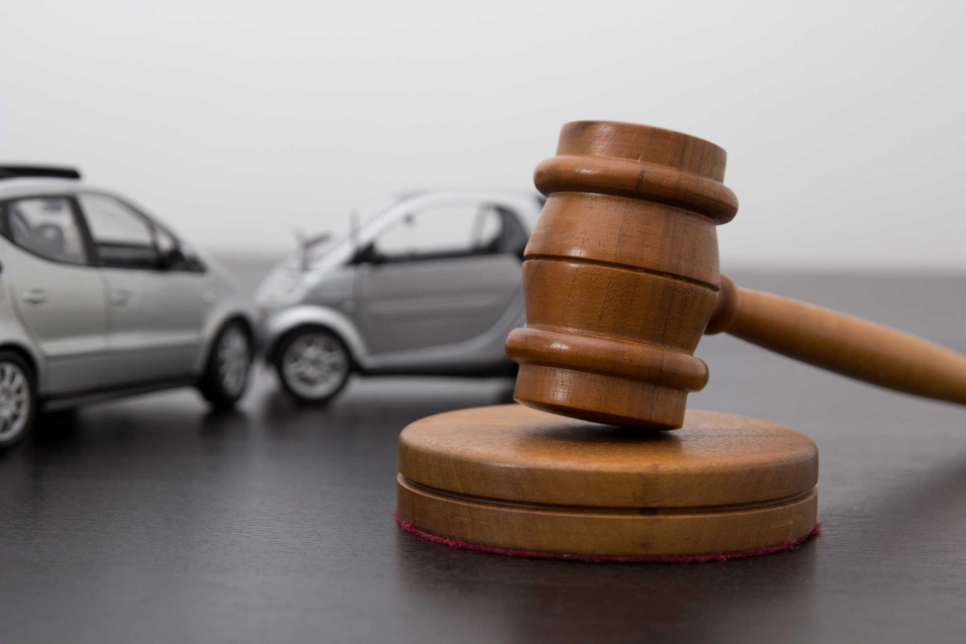 Gavel with model cars, symbolizing car accident legal action by a motor vehicle accident attorney. Gavel with model cars, symbolizing car accident legal action by a motor vehicle accident attorney.