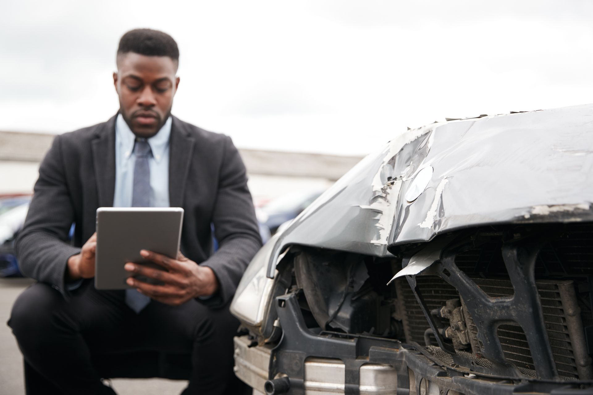 A lawyer inspecting damage to a car from a truck accident. A lawyer inspecting damage to a car from a truck accident.