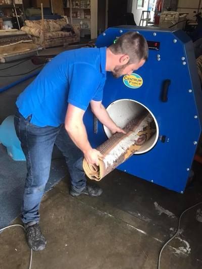 A man in a blue shirt is working on a machine