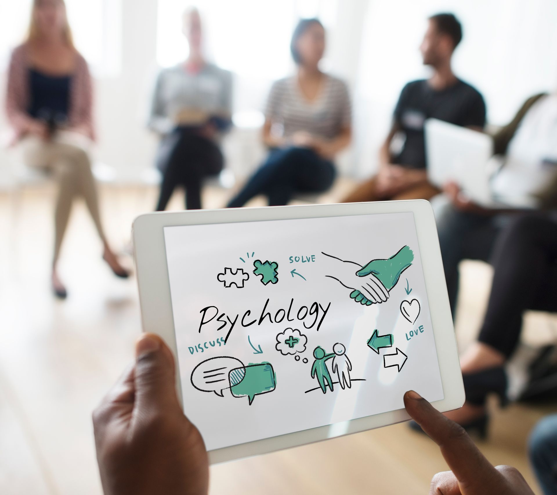A person is holding a tablet with the word psychology on it