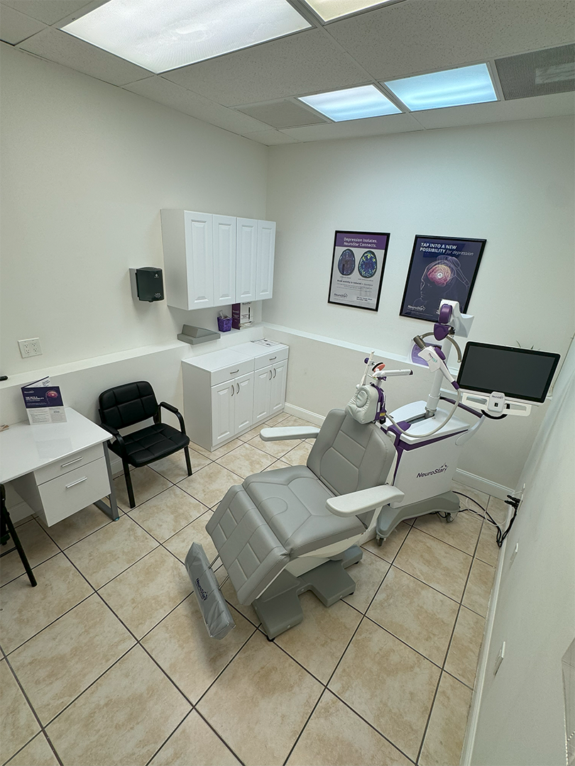 A dental office with a dental chair and a desk.