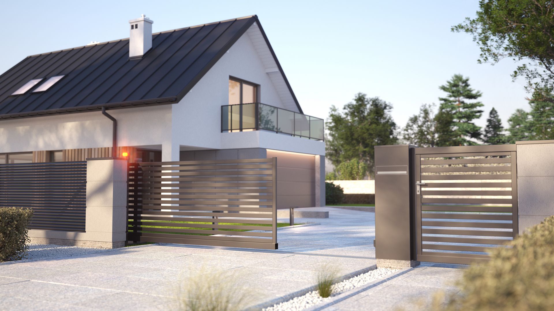 Modern house with a gray fence, gate, and gravel driveway. Sunlight highlights the home's exterior.
