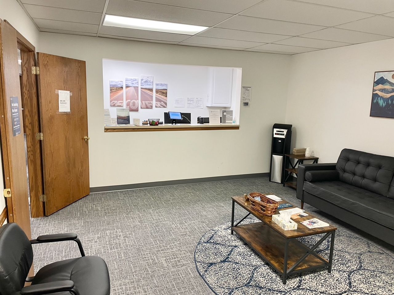 Waiting room with couch, coffee table, and reception desk.